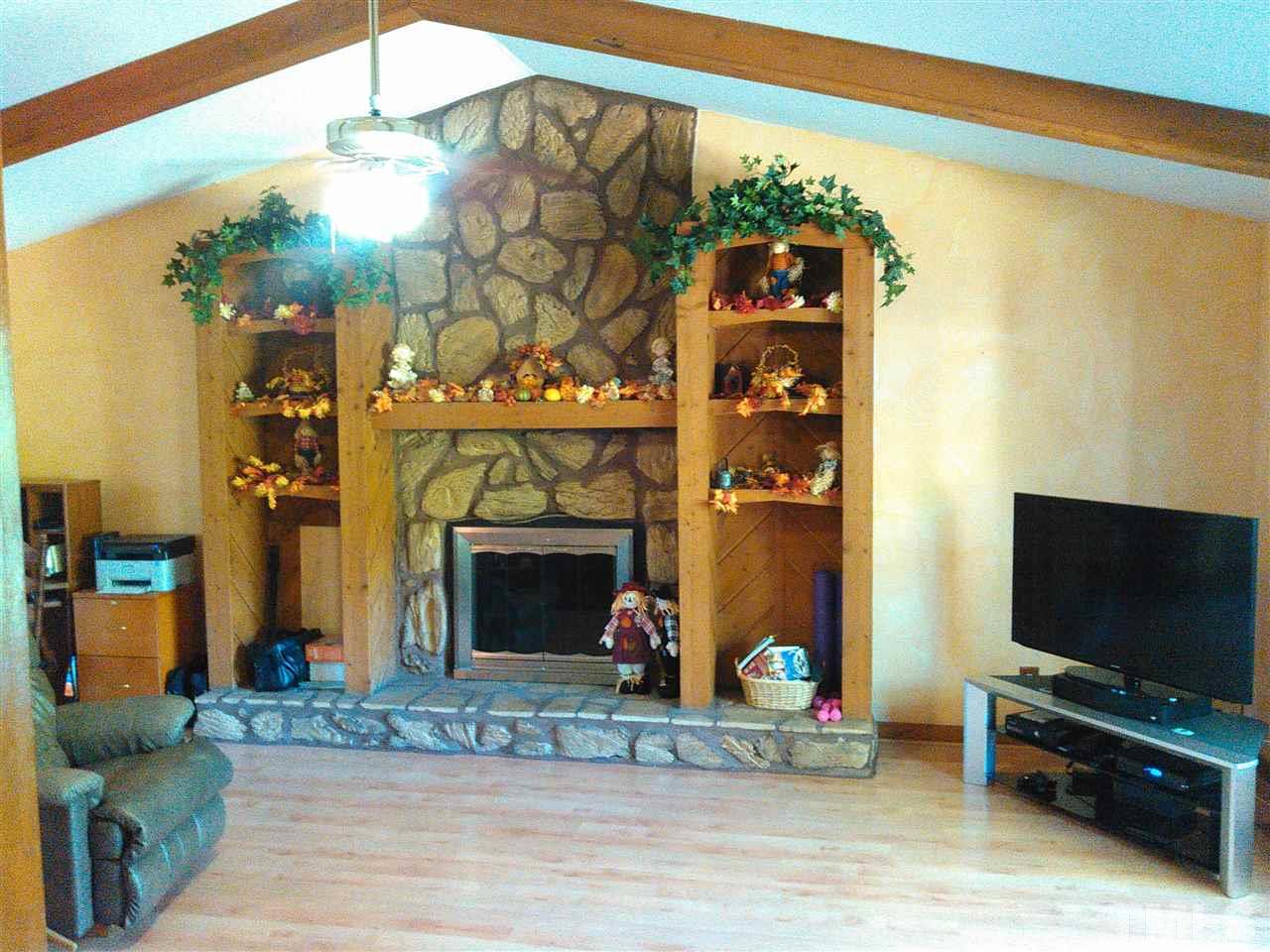 7508 Ray Road Raleigh, NC 27613 - Photo 4 of 18 a living room with furniture a flat screen tv and a fireplace