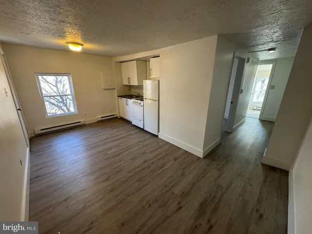 a view of a kitchen with wooden floor and electronic appliances