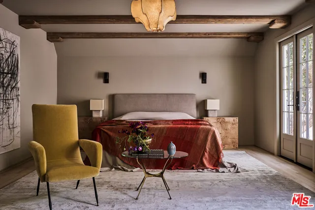 a bed sitting in a bedroom next to a window