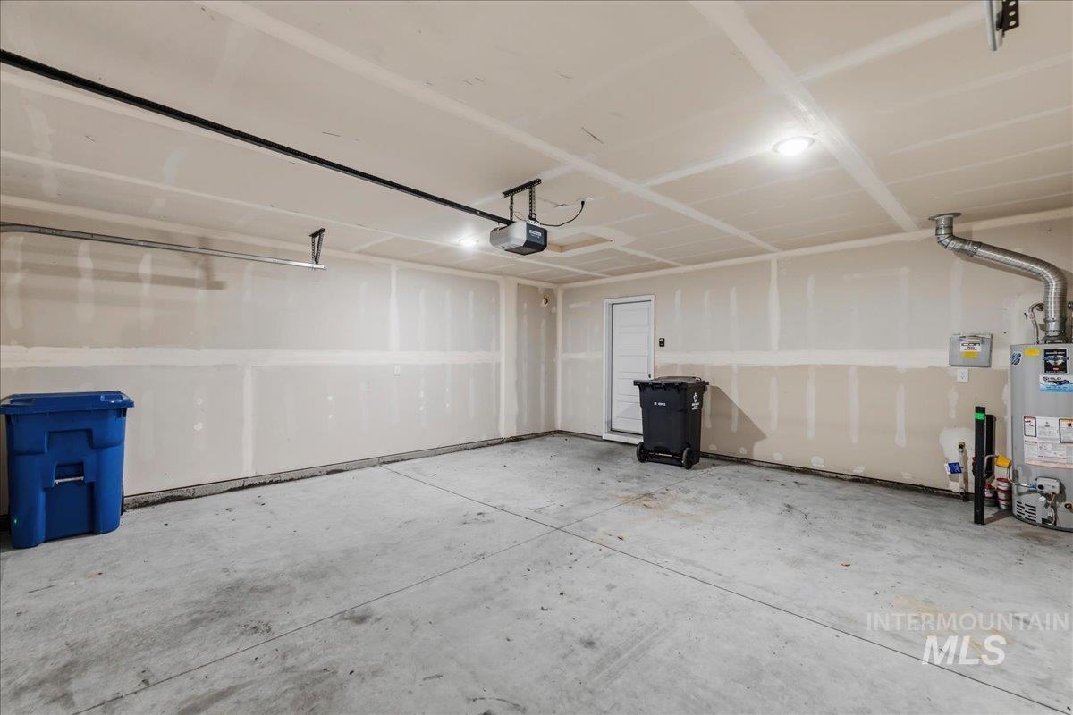 3091 S Green Boise, ID 83709 - Photo 23 of 27 Spacious garage featuring a concrete floor, exposed drywall, recessed lighting, and a garage door opener