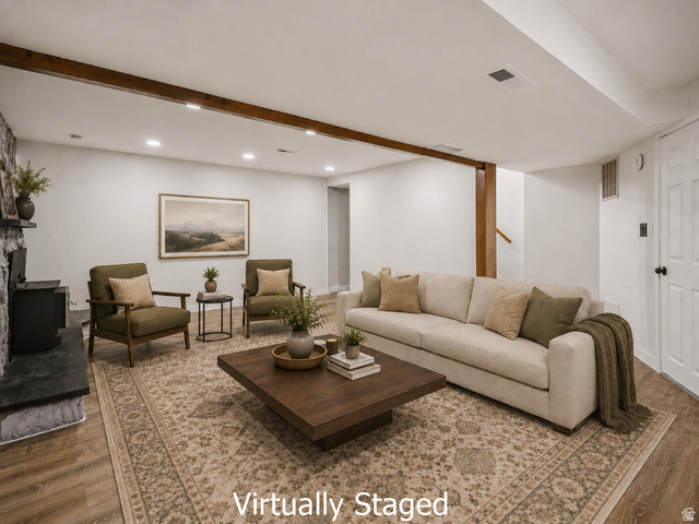 2693 Teal Way Sandy, UT 84093 - Photo 27 of 50 Spacious lower level featuring wood-finish flooring, a stone-faced fireplace with hearth, exposed wood ceiling beams, recessed lighting, and a paneled white door