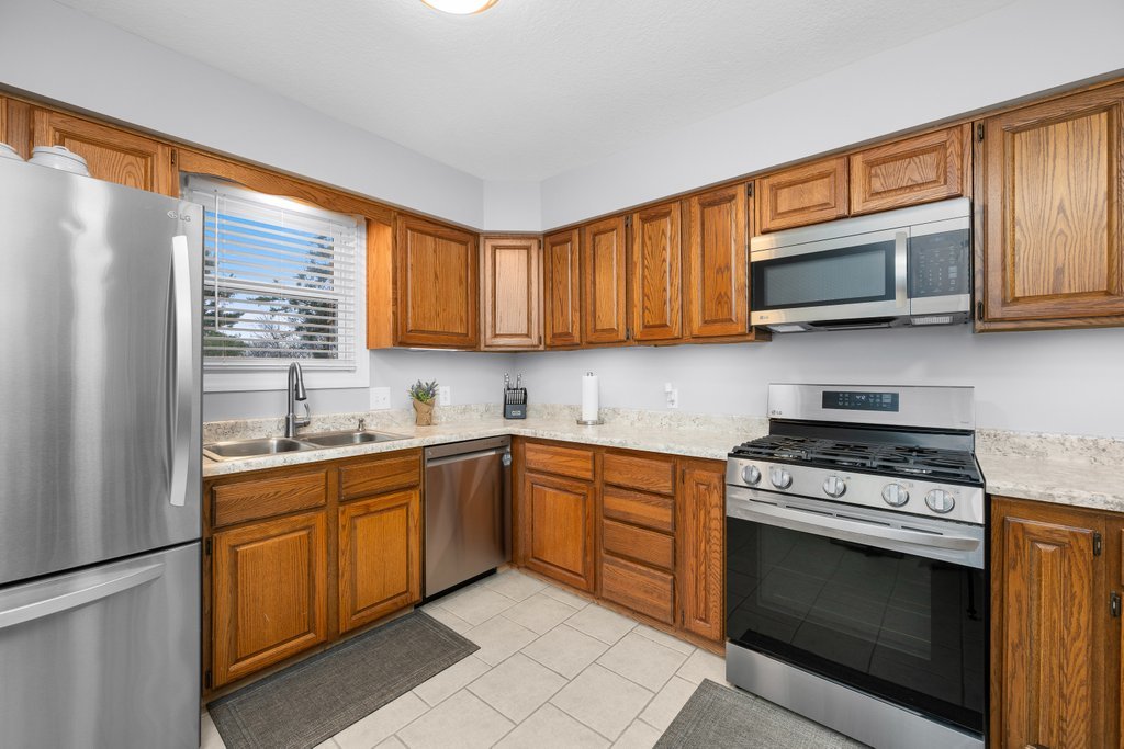 925 12th Avenue Moline, IL 61265 - Photo 11 of 36 a kitchen with stainless steel appliances granite countertop wooden cabinets stove top oven and sink