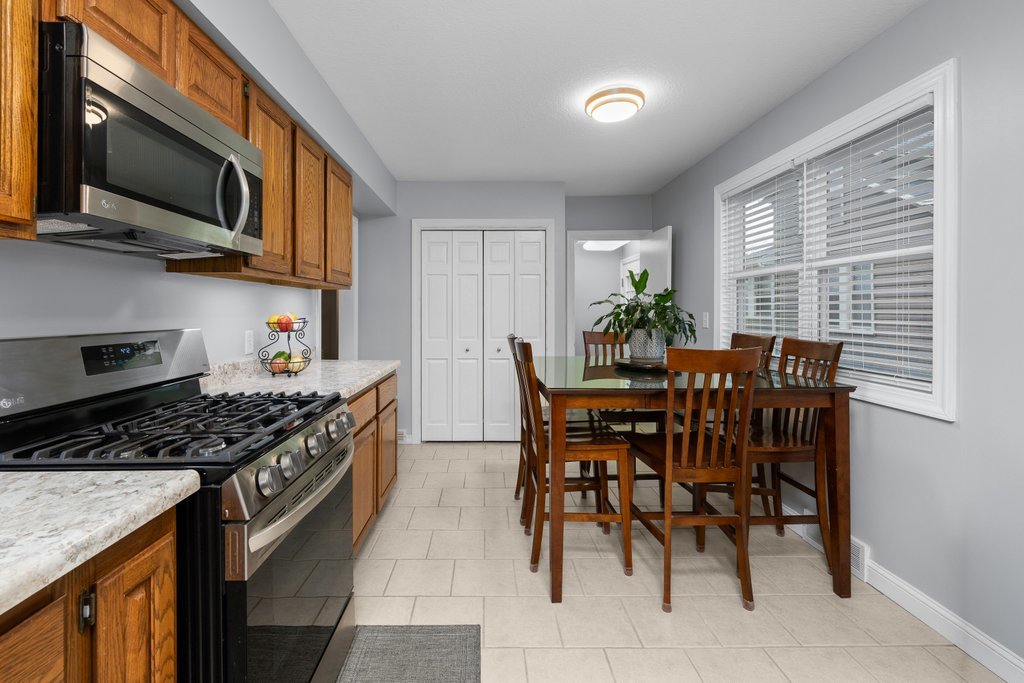 925 12th Avenue Moline, IL 61265 - Photo 12 of 36 a kitchen with stainless steel appliances granite countertop a stove top oven a sink a dining table and chairs