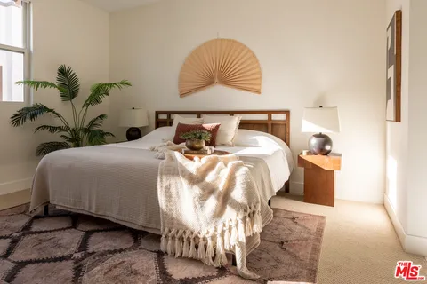 a bedroom with bed and a potted plant