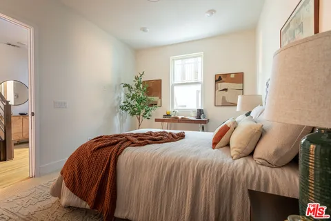 a bedroom with a bed and a potted plant