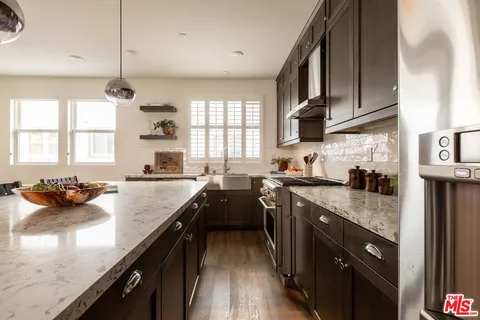 a kitchen with granite countertop a sink stove and cabinets