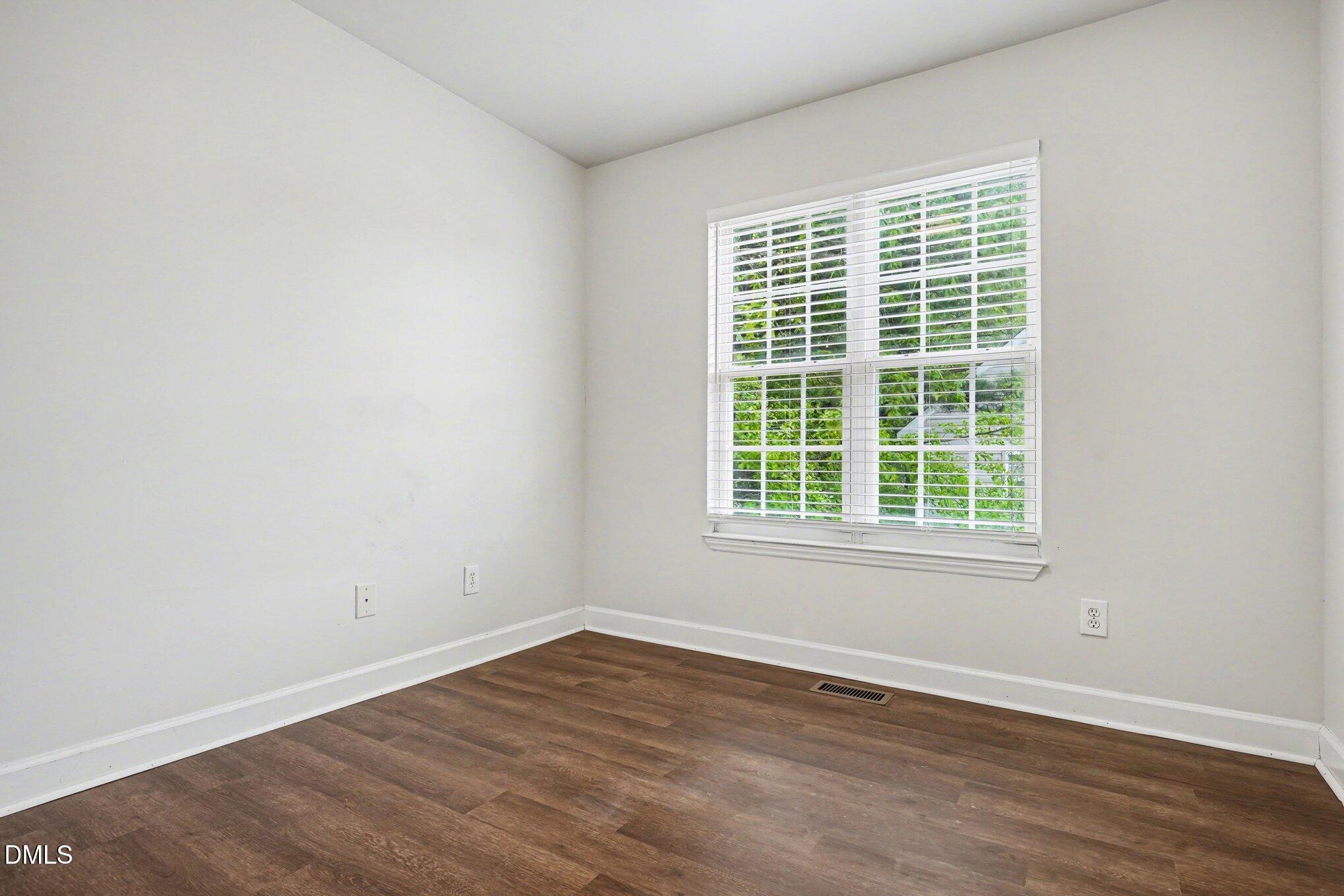 1237 Swingline Way Raleigh, NC 27610 - Photo 9 of 14 an empty room with wooden floor and windows
