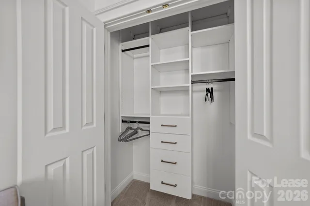 a view of walk in closet with empty racks