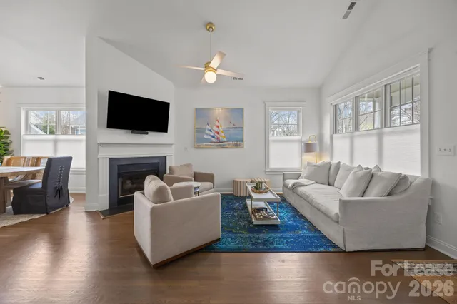 a living room with furniture a flat screen tv and a fireplace