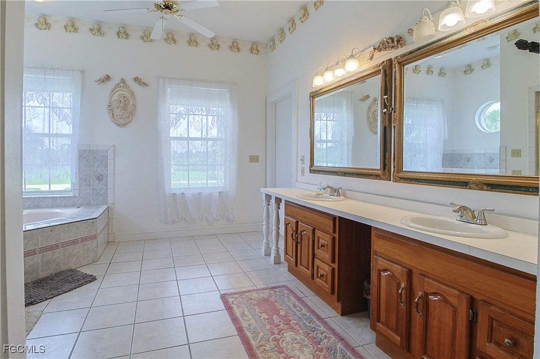21810 Pearl Street Alva, FL 33920 - Photo 38 of 50 a spacious bathroom with a double vanity sink a mirror and a bathtub
