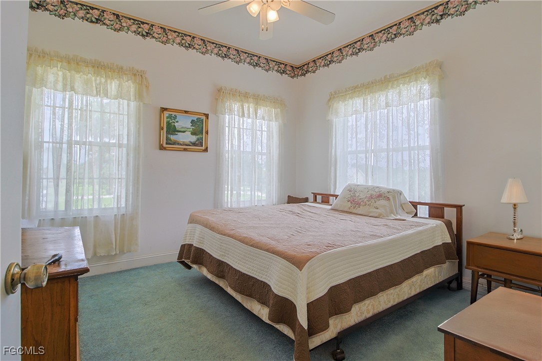 21810 Pearl Street Alva, FL 33920 - Photo 40 of 50 a bedroom with a bed and a chandelier
