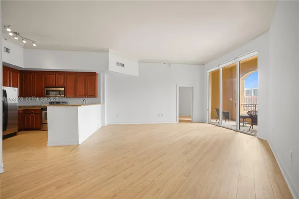 a view of a kitchen with a sink and dishwasher with wooden floor