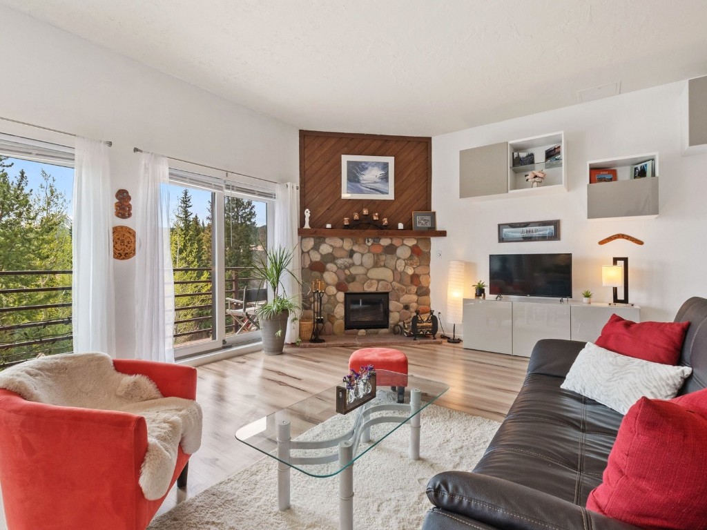 9825 Ryan Gulch Road, Unit B108 Silverthorne, CO 80498 - Photo 1 of 26 a living room with furniture and a fireplace