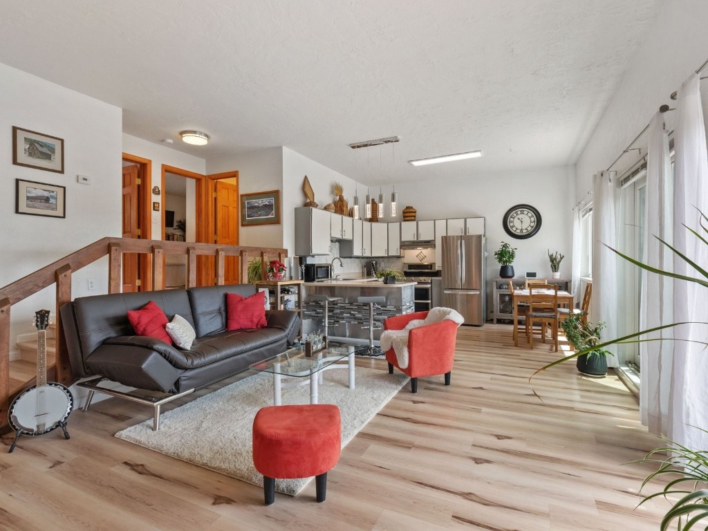 9825 Ryan Gulch Road, Unit B108 Silverthorne, CO 80498 - Photo 2 of 26 a living room with furniture kitchen view and a wooden floor