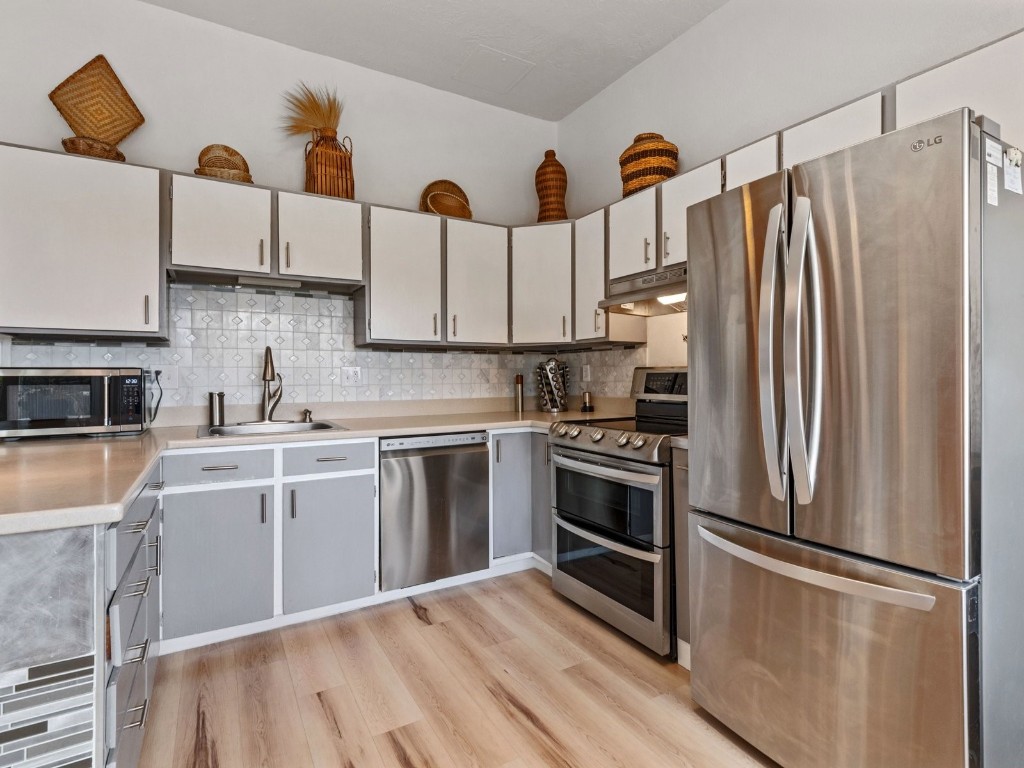 9825 Ryan Gulch Road, Unit B108 Silverthorne, CO 80498 - Photo 5 of 26 a kitchen with stainless steel appliances a refrigerator sink and microwave