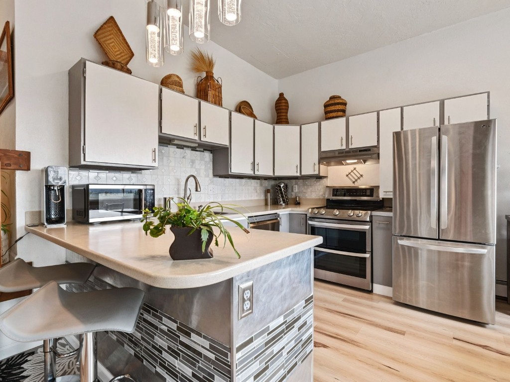 9825 Ryan Gulch Road, Unit B108 Silverthorne, CO 80498 - Photo 6 of 26 a kitchen with stainless steel appliances a center island and a refrigerator
