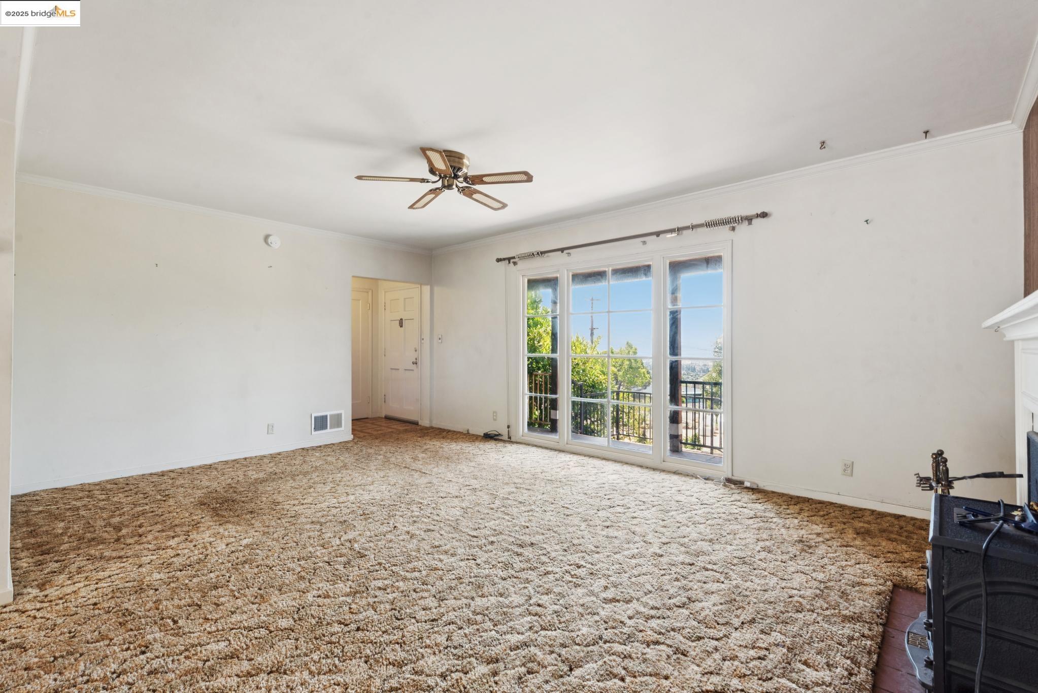 4751 Lincoln Avenue Oakland, CA 94602 - Photo 14 of 60 Unfurnished living room with ornamental molding, a ceiling fan, carpet flooring, and a fireplace