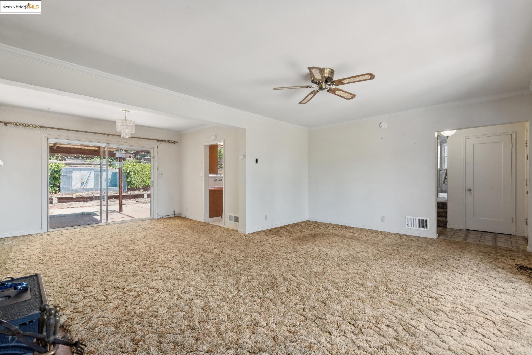 4751 Lincoln Avenue Oakland, CA 94602 - Photo 15 of 60 Unfurnished living room with ornamental molding, a chandelier, carpet floors, and ceiling fan
