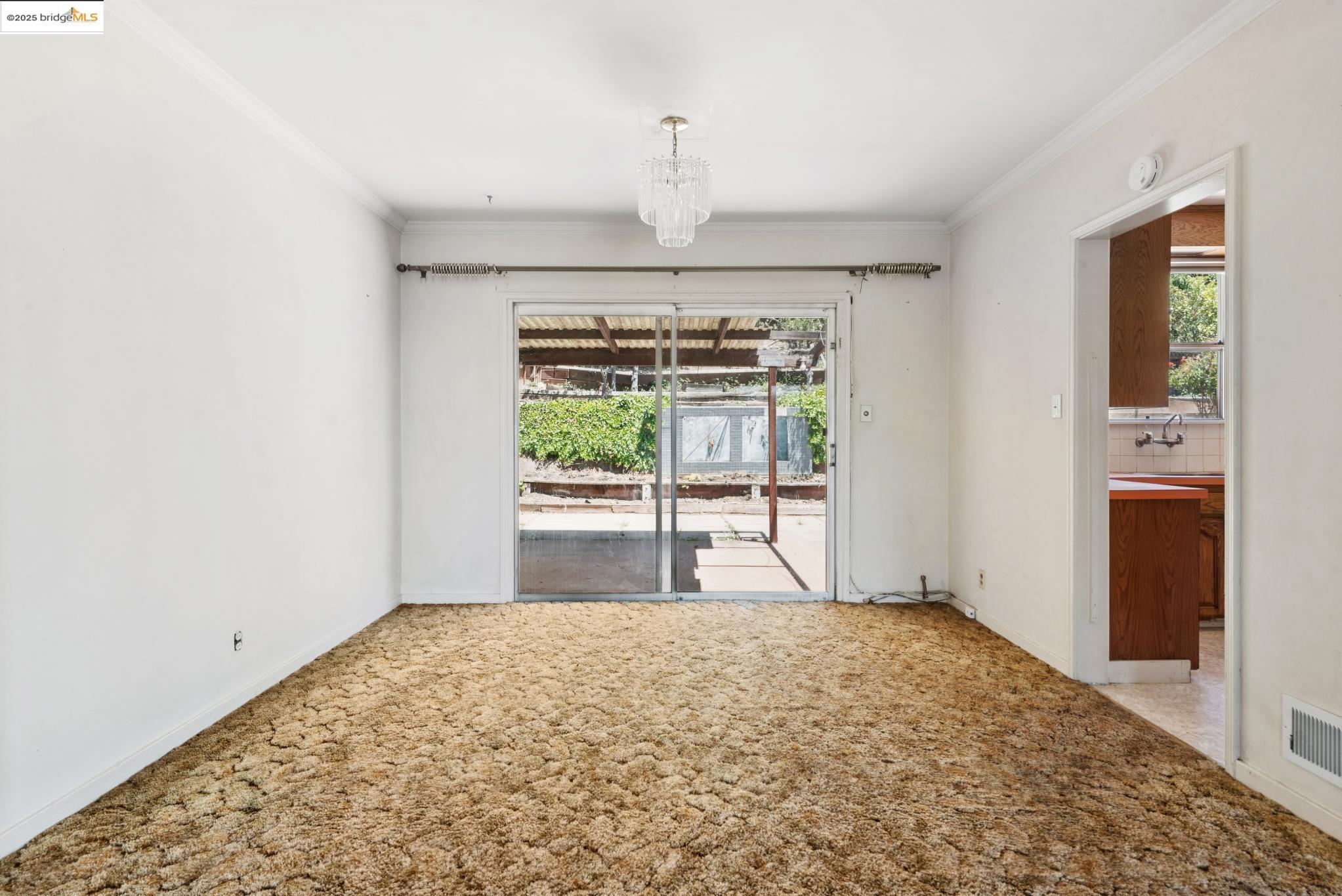 4751 Lincoln Avenue Oakland, CA 94602 - Photo 16 of 60 Unfurnished room with crown molding, carpet floors, and a chandelier