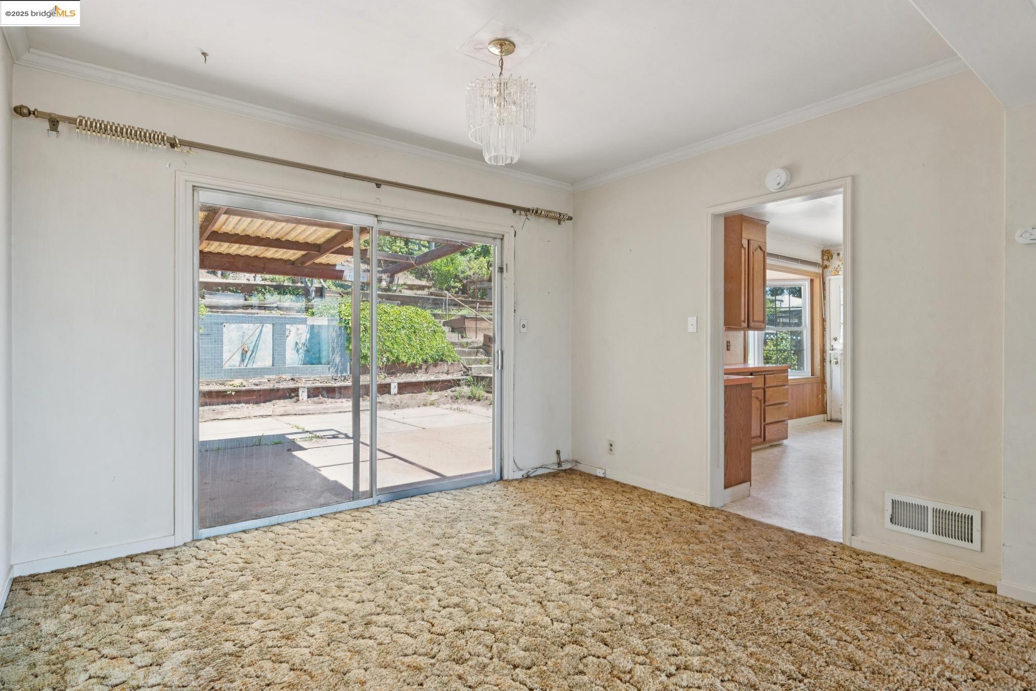 4751 Lincoln Avenue Oakland, CA 94602 - Photo 17 of 60 Spare room with crown molding, light carpet, and a chandelier