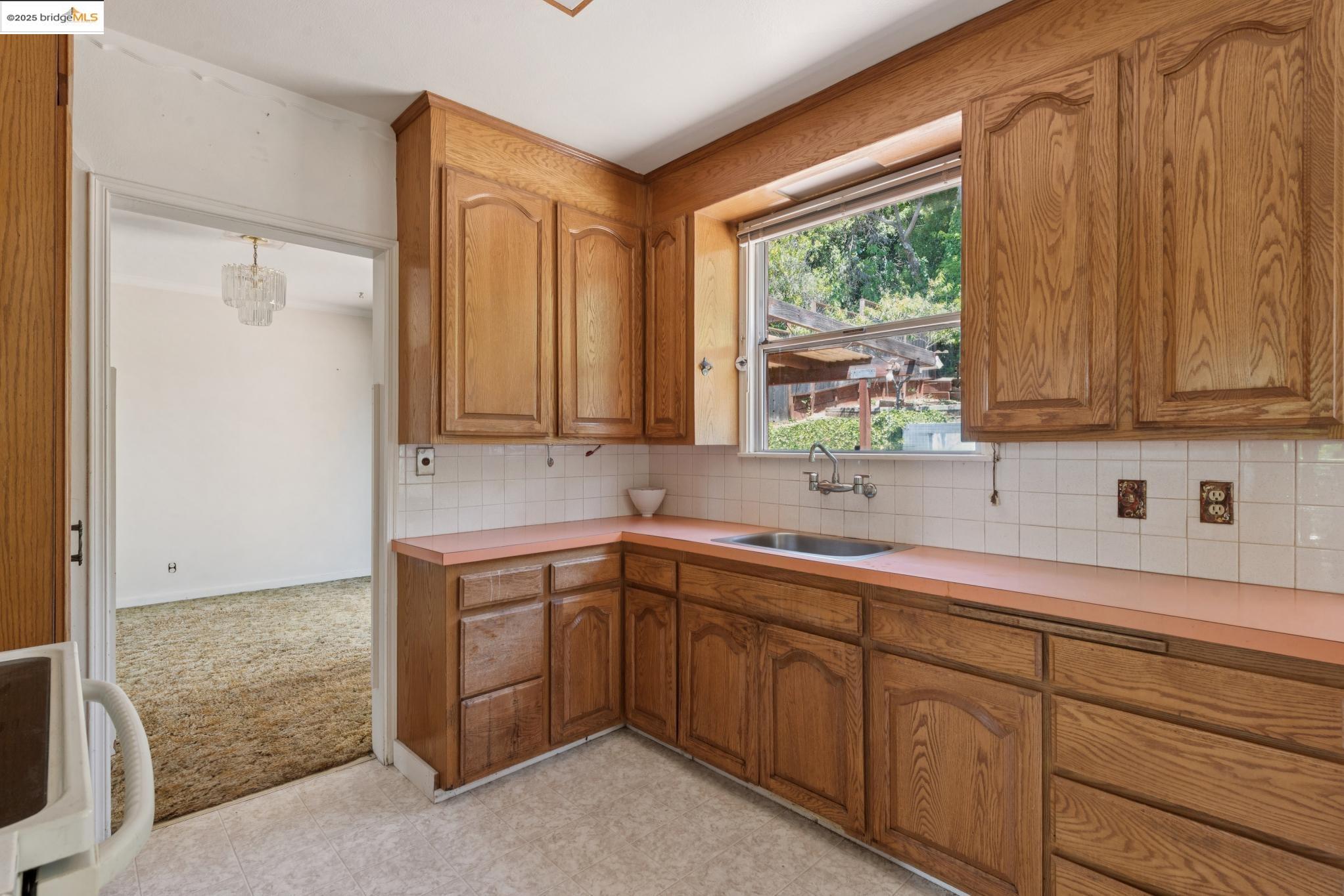 4751 Lincoln Avenue Oakland, CA 94602 - Photo 21 of 60 Kitchen featuring decorative backsplash, brown cabinets, light countertops, and light colored carpet