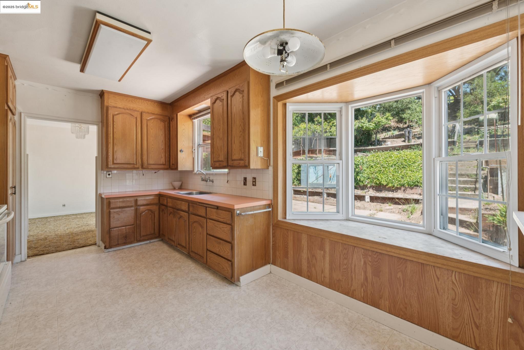 4751 Lincoln Avenue Oakland, CA 94602 - Photo 25 of 60 Kitchen featuring brown cabinetry, light countertops, backsplash, and light flooring