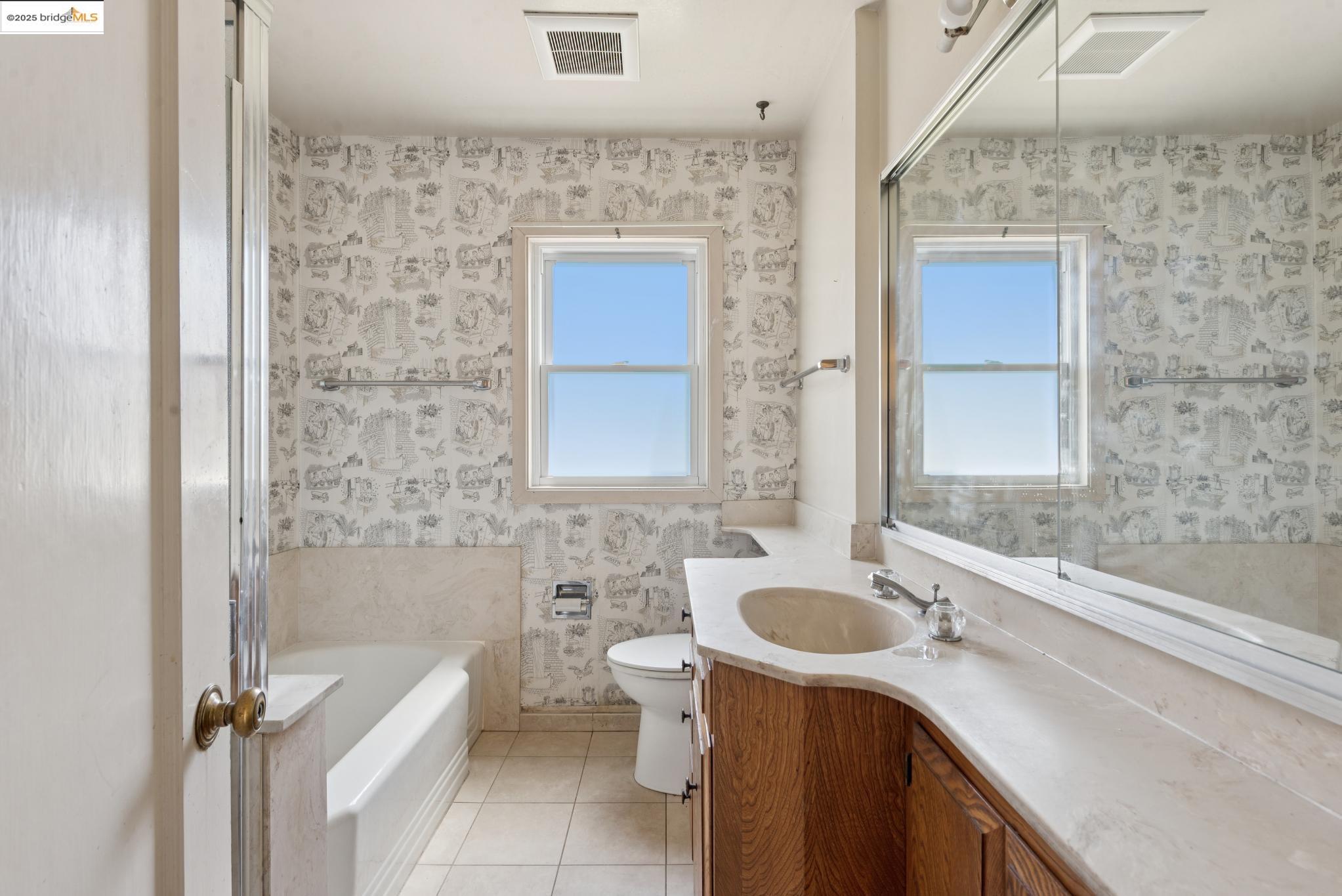 4751 Lincoln Avenue Oakland, CA 94602 - Photo 34 of 60 Bathroom featuring light tile patterned flooring, vanity, wallpapered walls, and a garden tub