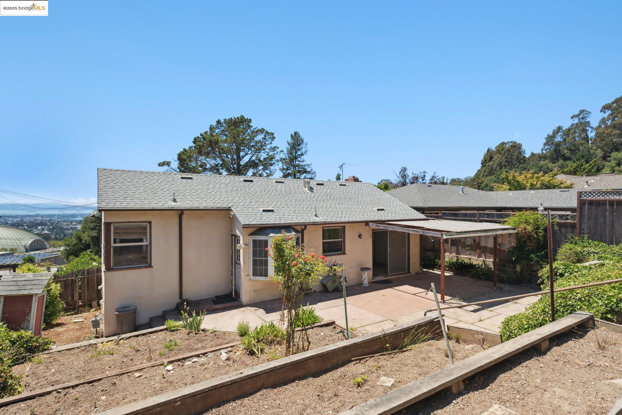 4751 Lincoln Avenue Oakland, CA 94602 - Photo 52 of 60 Rear view of property with roof with shingles, a sunroom, stucco siding, and a vegetable garden