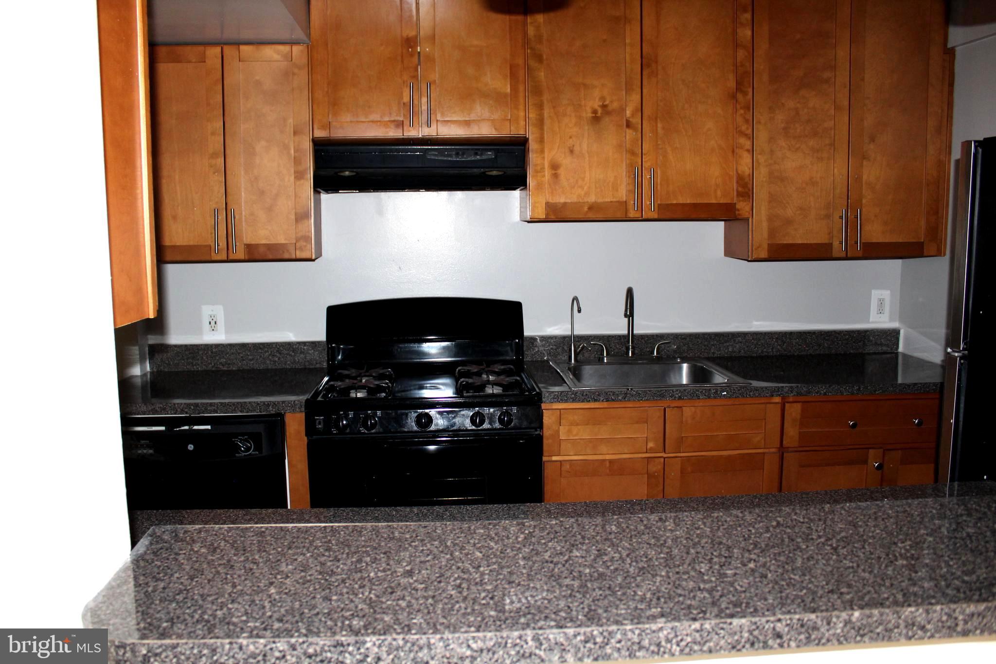 11204 Cherry Hill Road, Unit T2 Beltsville, MD 20705 - Photo 25 of 37 a kitchen with stainless steel appliances granite countertop a stove a sink and a microwave
