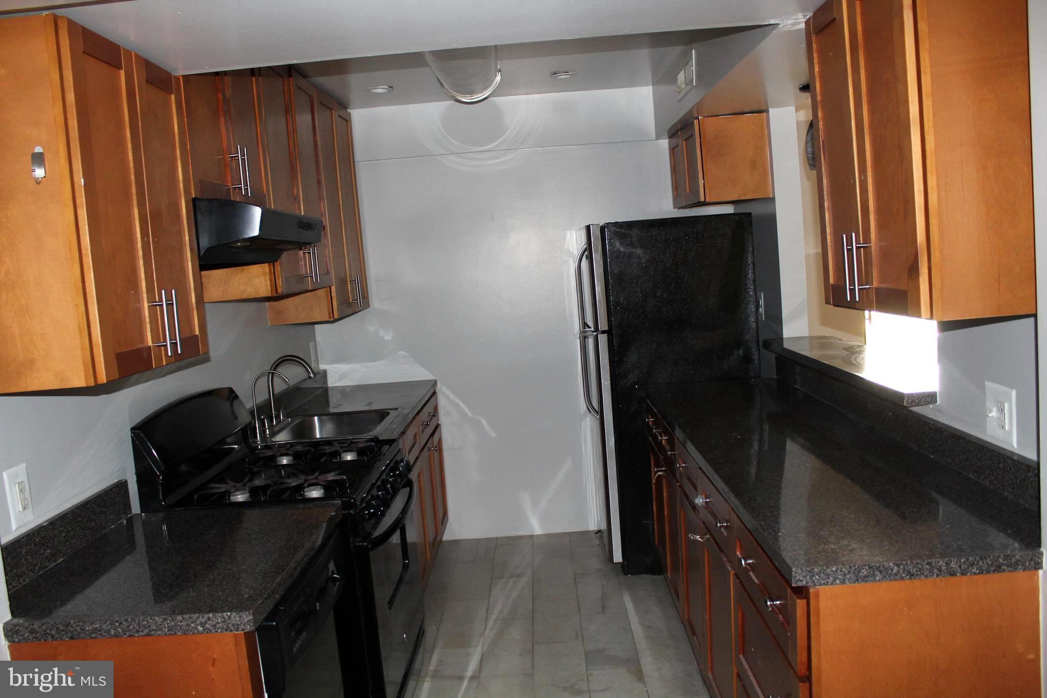 11204 Cherry Hill Road, Unit T2 Beltsville, MD 20705 - Photo 8 of 37 a kitchen with a sink and a refrigerator