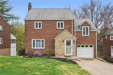 a front view of a house with a garden and yard