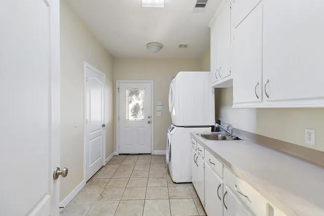 an empty room with wooden floor chandelier fan and windows