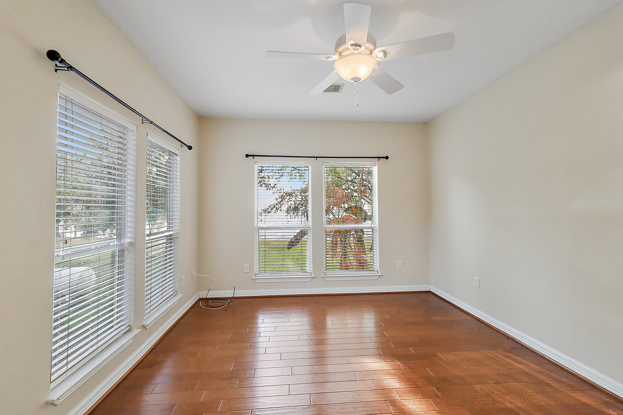 4521 West Bayshore Road, Unit A Anahuac, TX 77514 - Photo 17 of 34 an empty room with wooden floor chandelier fan and windows