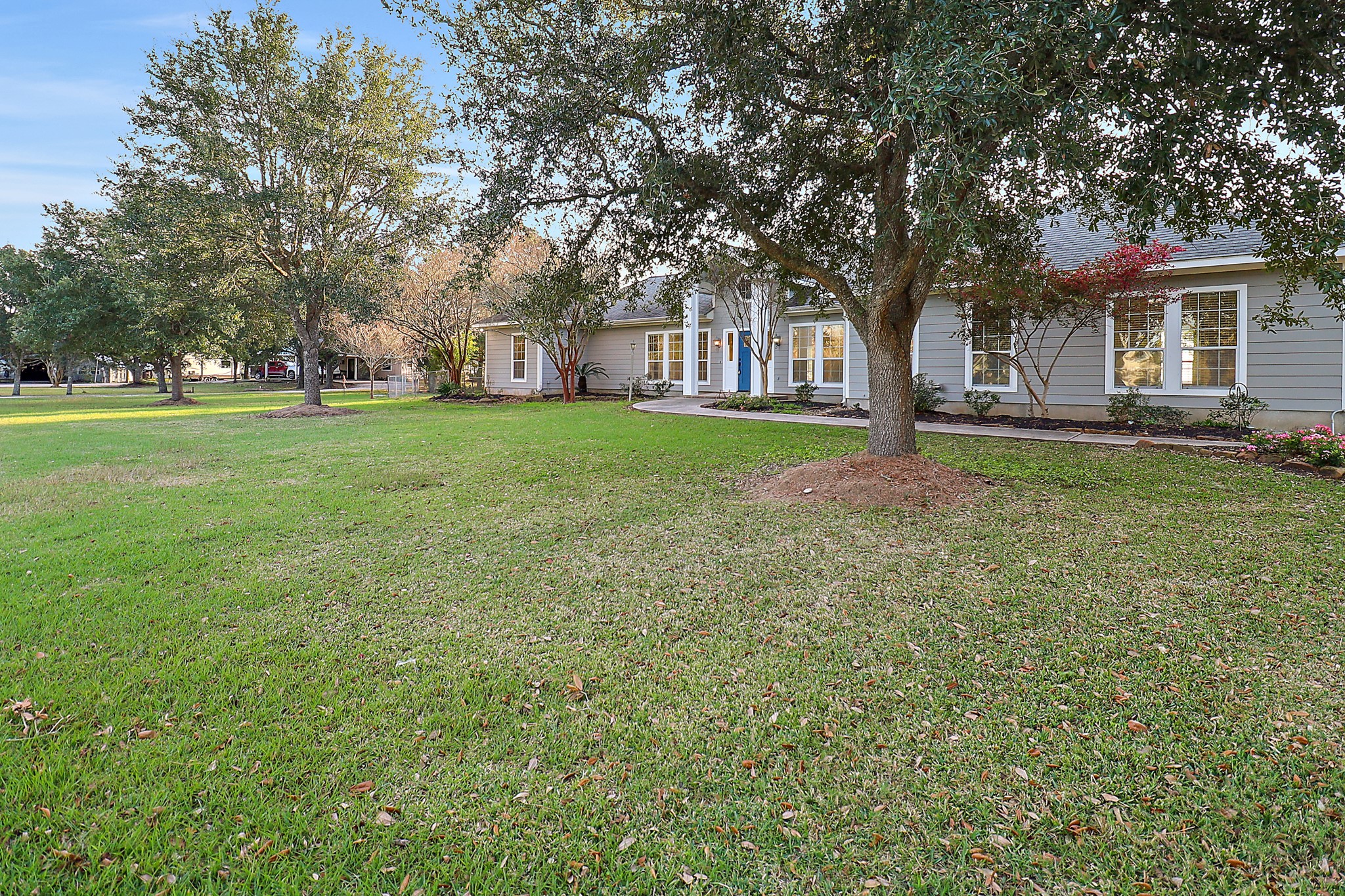 4521 West Bayshore Road, Unit A Anahuac, TX 77514 - Photo 25 of 34 a view of a house with a big yard and large trees