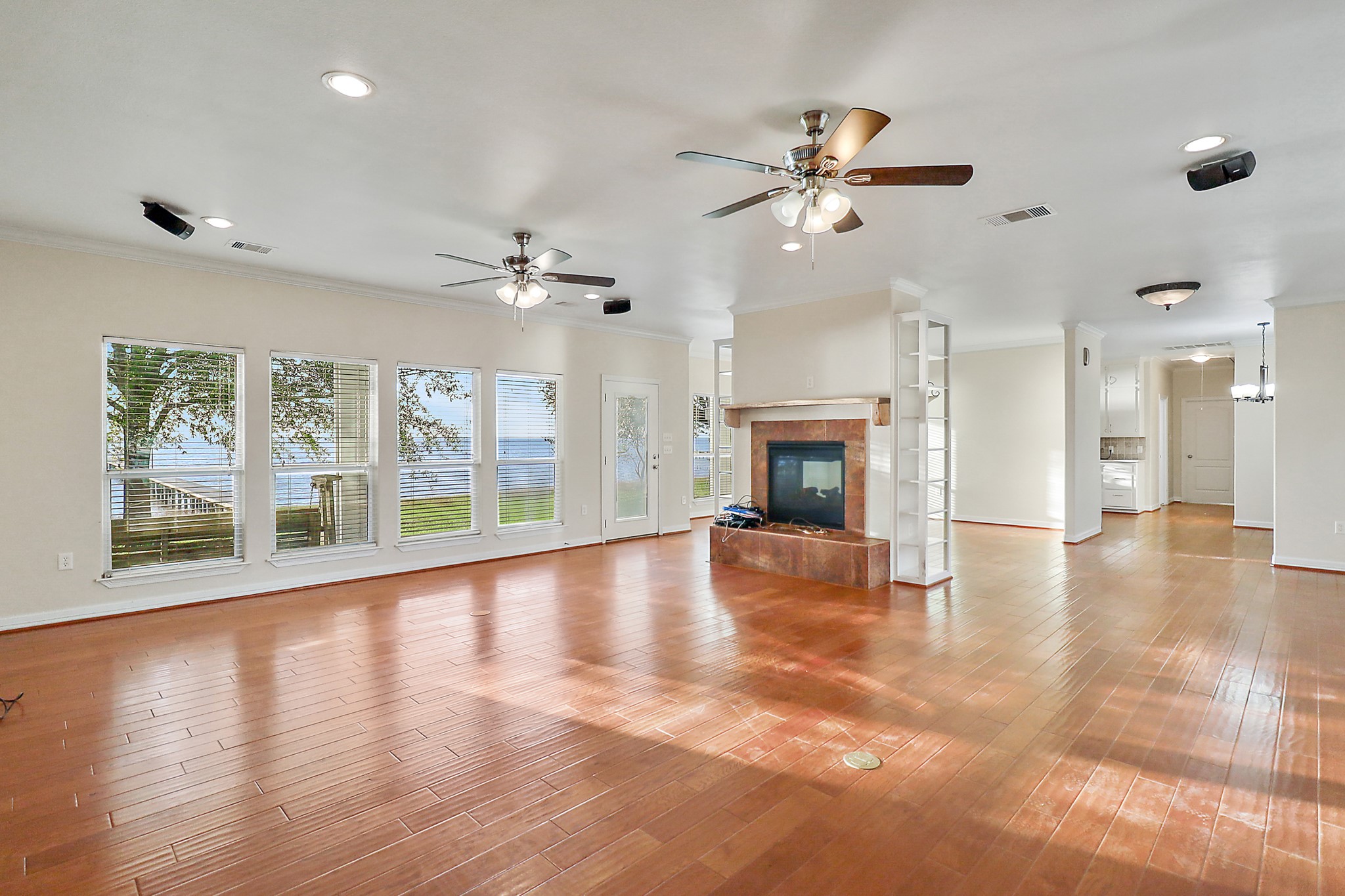 4521 West Bayshore Road, Unit A Anahuac, TX 77514 - Photo 6 of 34 a view of an empty room with wooden floor fireplace and a window