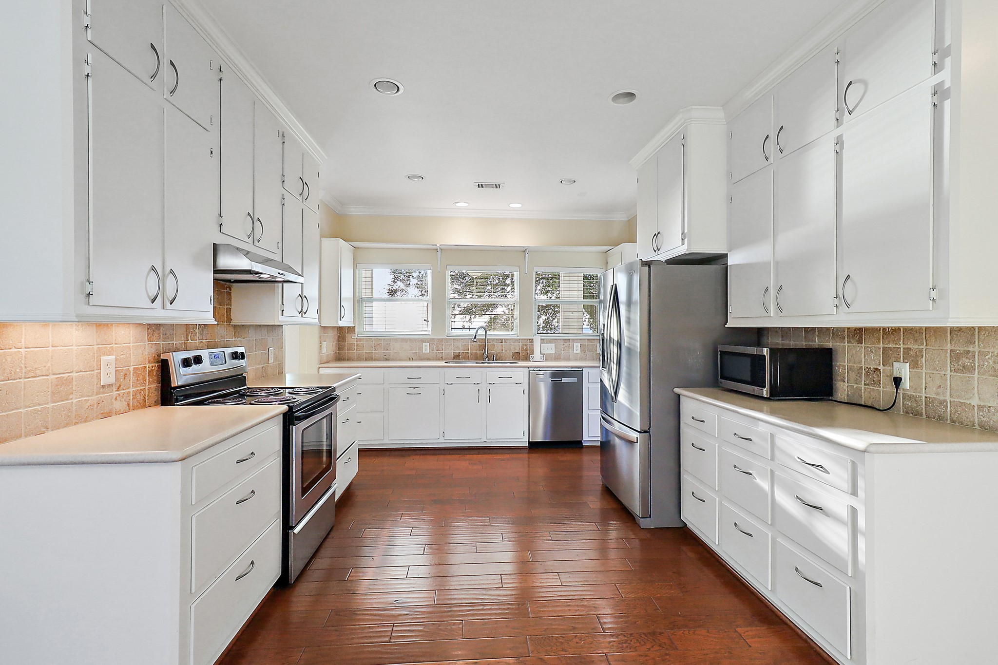 4521 West Bayshore Road, Unit A Anahuac, TX 77514 - Photo 7 of 34 a kitchen with white cabinets and white appliances