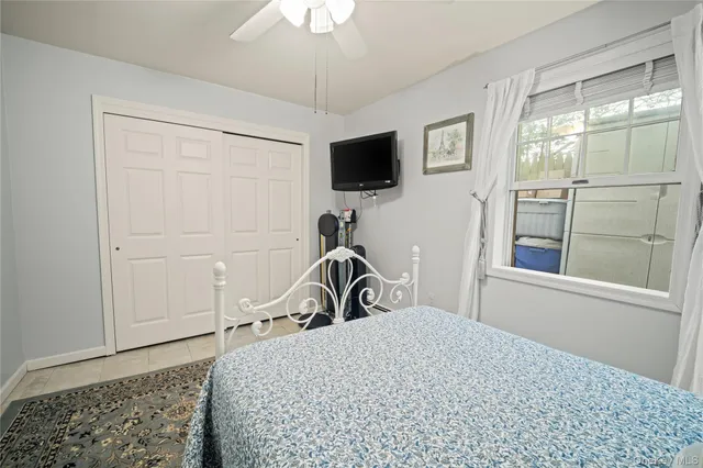 a bedroom with a bed and a flat tv screen on the dresser