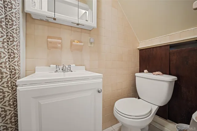 a bathroom with a sink toilet and a mirror