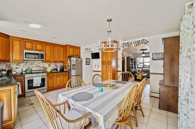 a kitchen with stainless steel appliances kitchen island granite countertop a sink and dishwasher a refrigerator with wooden cabinets