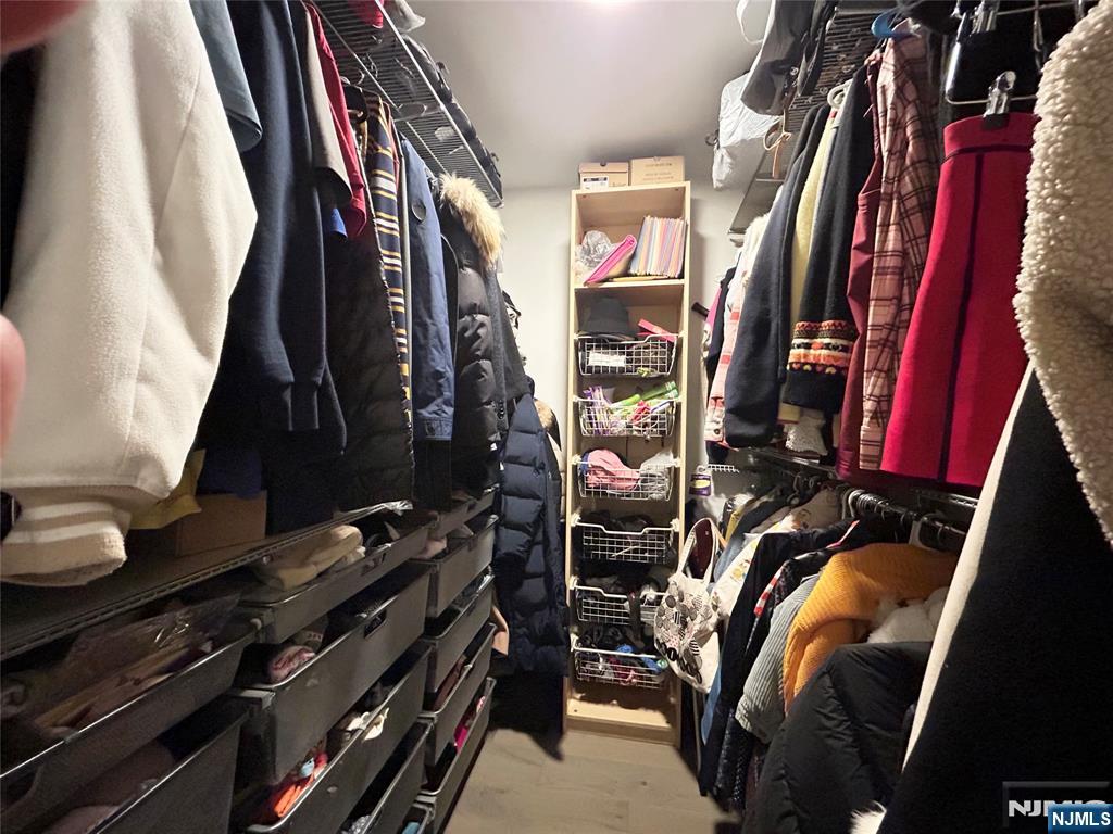 18 Independence Way, Unit J018 Edgewater, NJ 07020 - Photo 11 of 18 a view of walk in closet with clothes and shoes