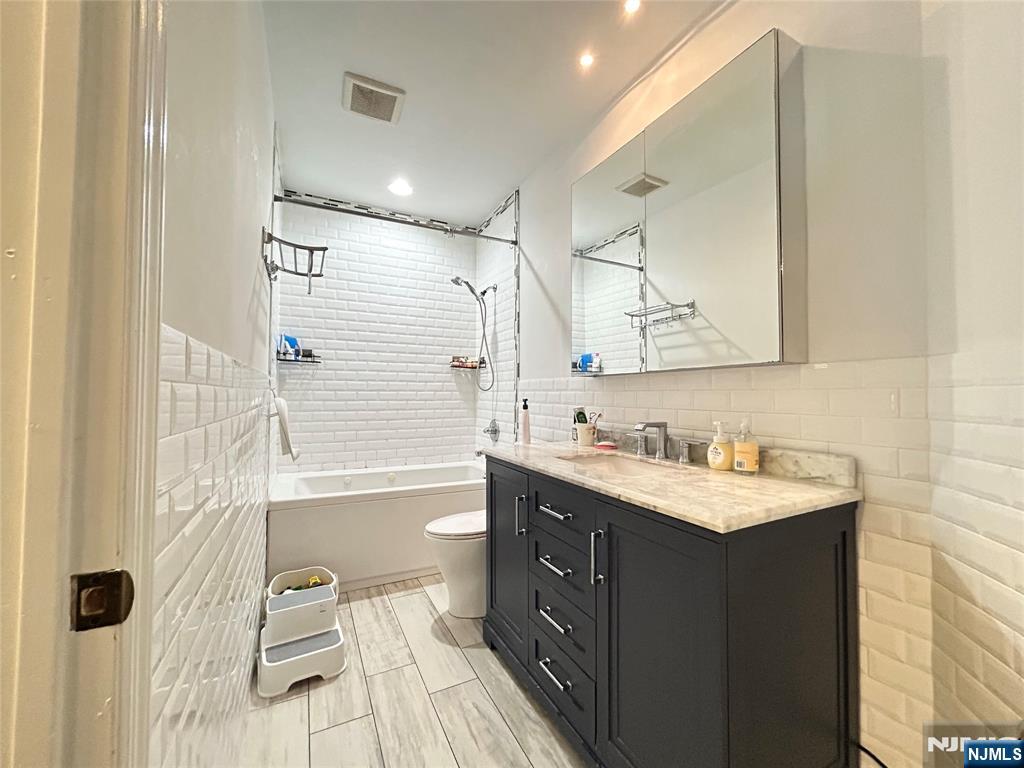 18 Independence Way, Unit J018 Edgewater, NJ 07020 - Photo 6 of 18 a bathroom with a sink mirror toilet and bathtub