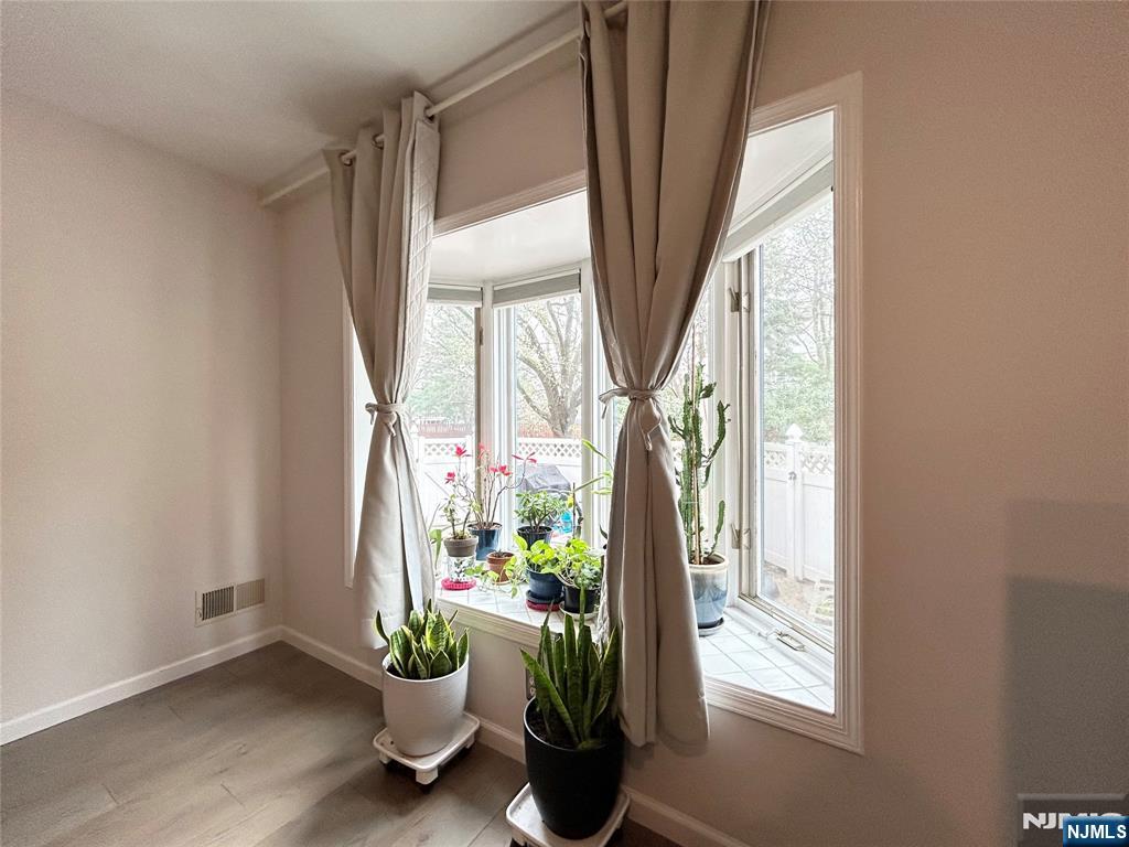 18 Independence Way, Unit J018 Edgewater, NJ 07020 - Photo 7 of 18 a vase of flowers sitting on a floor next to a window