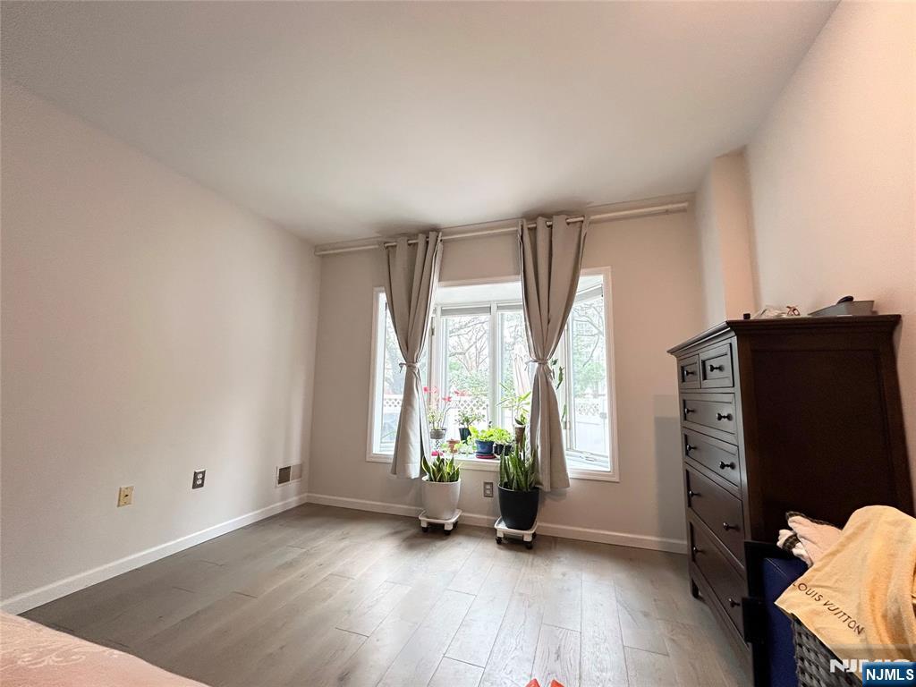 18 Independence Way, Unit J018 Edgewater, NJ 07020 - Photo 8 of 18 wooden floor in an empty room with a window