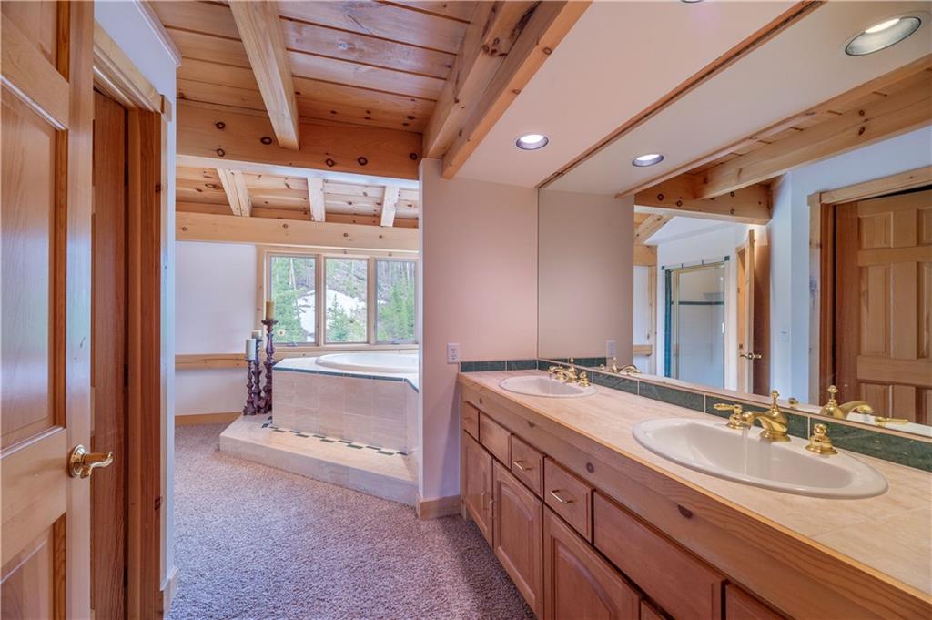 1202 Tiger Road Breckenridge, CO 80424 - Photo 24 of 35 a bathroom with a granite countertop sink and a large mirror