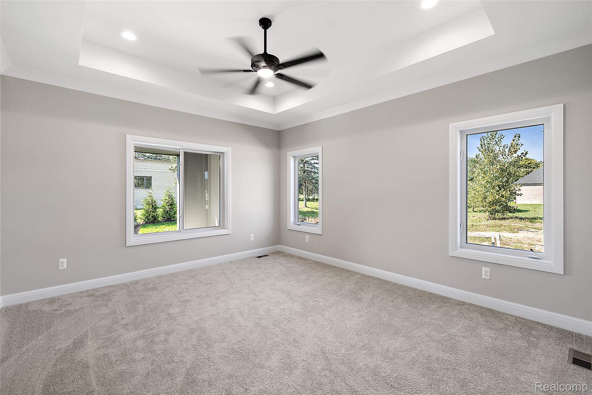 8267 Sandi Lane Romeo, MI 48065 - Photo 26 of 46 Tray ceiling with recessed lighting and a ceiling fan, light-toned carpeting, and multiple windows