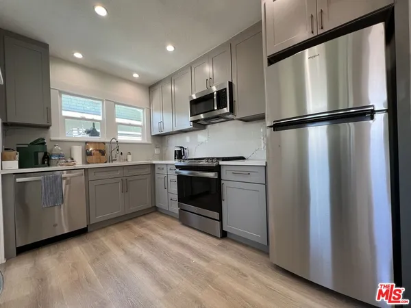 a kitchen with stainless steel appliances granite countertop a refrigerator sink and microwave