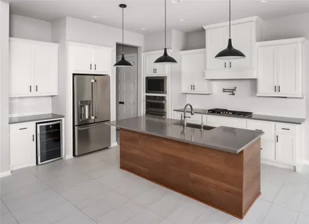 a kitchen with stainless steel appliances granite countertop a sink a stove and a refrigerator