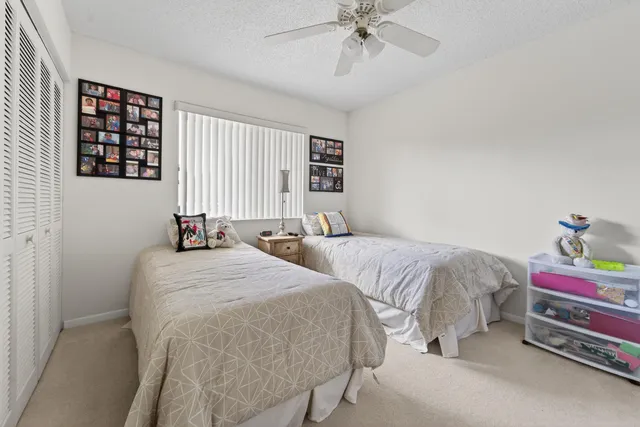 a bedroom with a bed and large windows