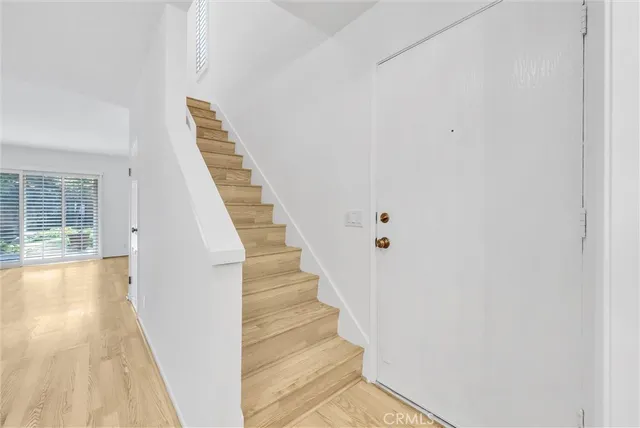 a kitchen with stainless steel appliances granite countertop white cabinets a sink a stove a microwave and wooden floors