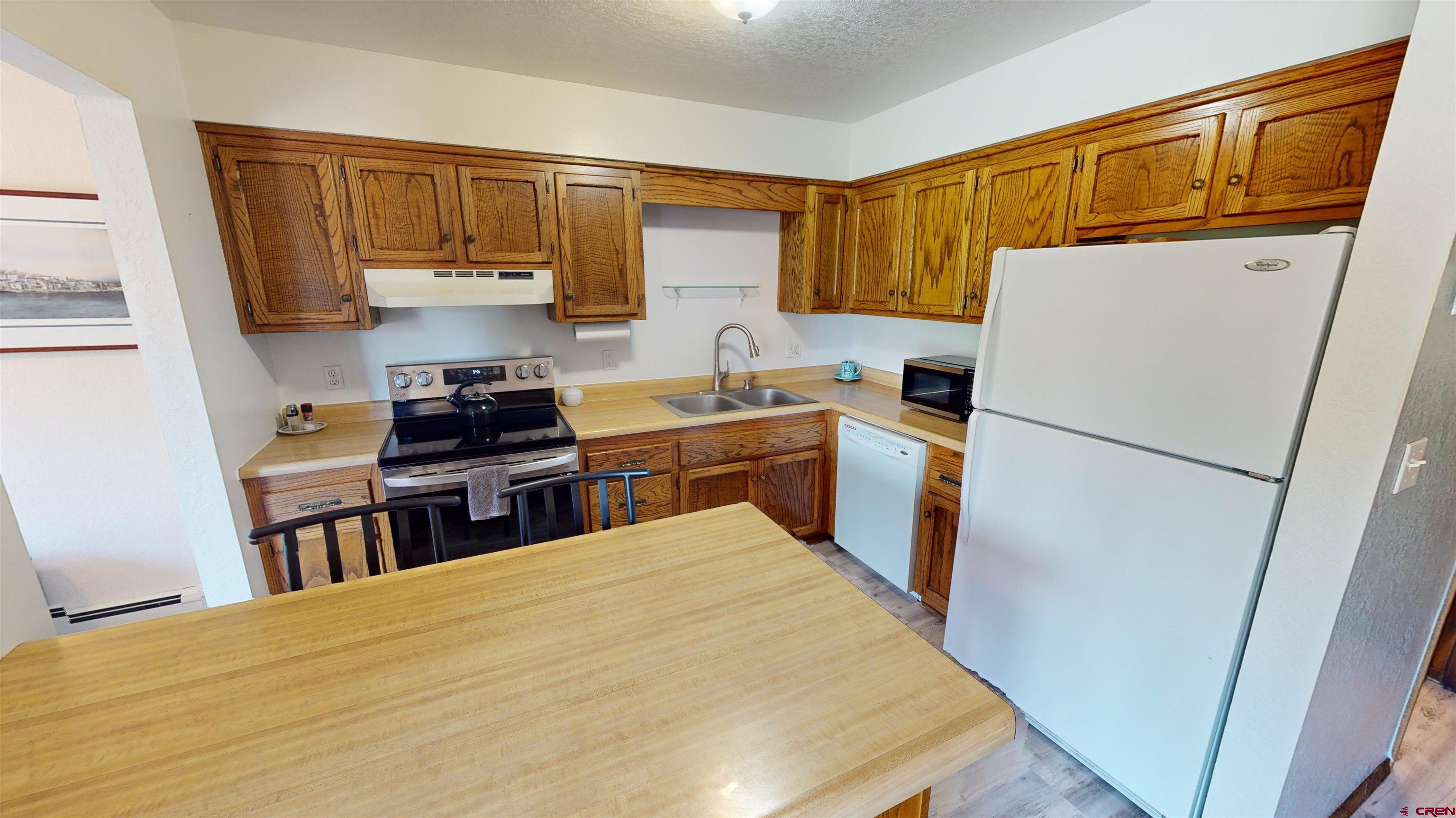 232 Pine Ridge Loop Durango, CO 81301 - Photo 8 of 35 a kitchen with a refrigerator a stove top oven a sink and dishwasher